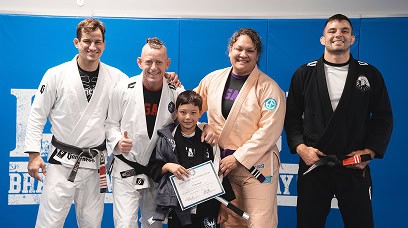 Group of students and instructor celebrating at Legacy Jiu-Jitsu Academy.