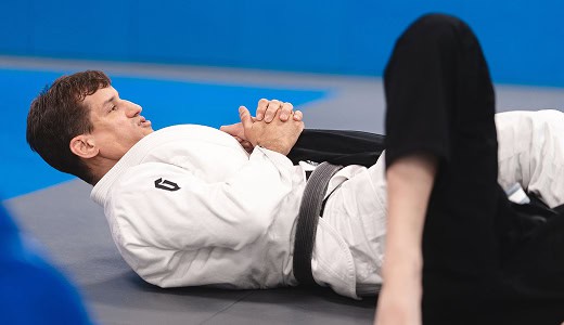 Male practitioner practicing Brazilian Jiu-Jitsu techniques on the mat.