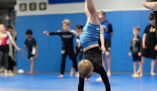 Young children practicing handstands during kids martial arts class at Legacy Jiu-Jitsu Academy.
