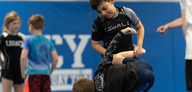 Young children practicing Brazilian Jiu-Jitsu techniques at Legacy Jiu-Jitsu Academy.