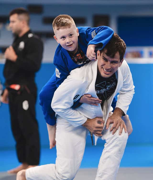 Young child practicing Brazilian Jiu-Jitsu with instructor at Legacy BJJ.