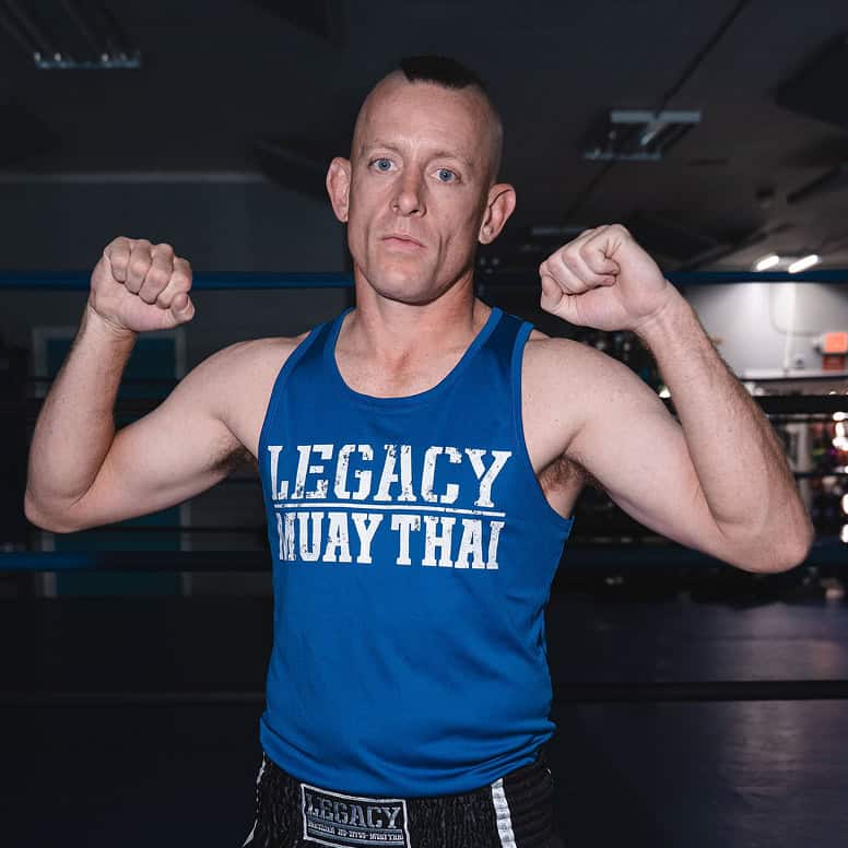 Male martial artist flexing muscles at Legacy Jiu-Jitsu Academy.